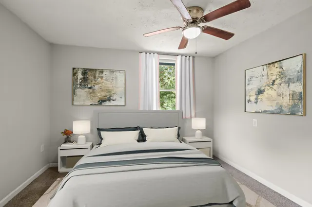 a bedroom with a bed and a painting on the wall