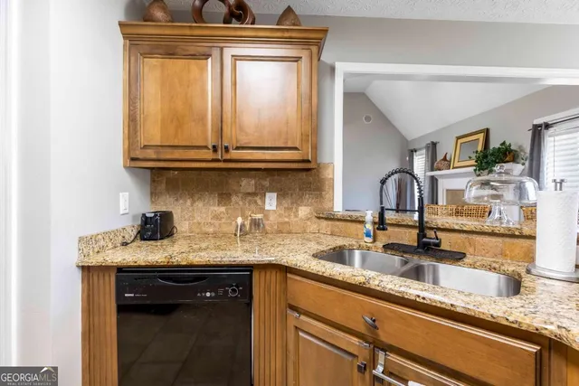 a kitchen with granite countertop a sink and cabinets