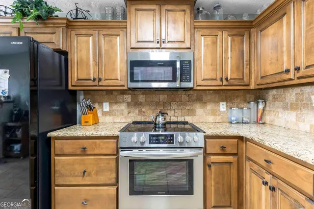 a kitchen with granite countertop cabinets stainless steel appliances and a counter space