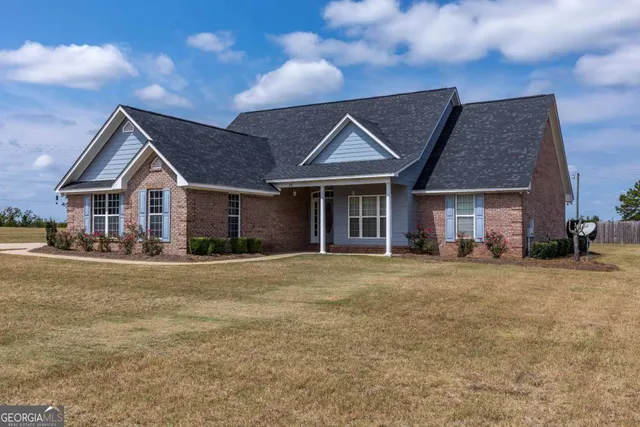 a front view of a house with a garden and yard