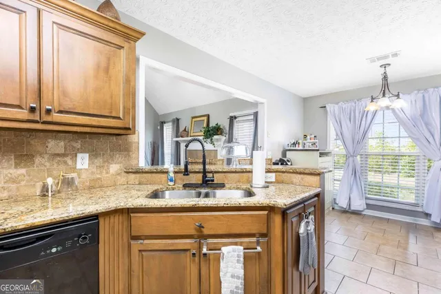a kitchen with granite countertop a sink and a window