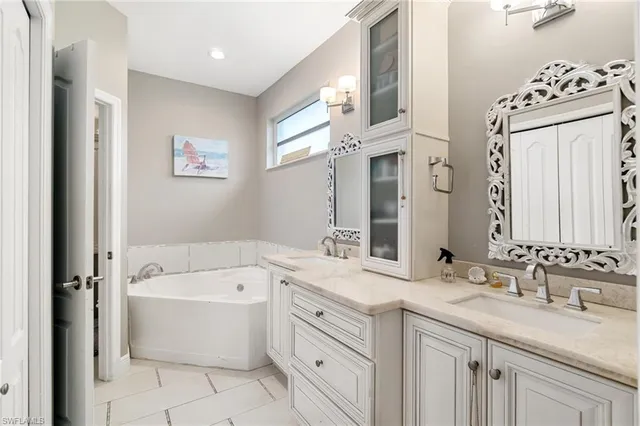 a bathroom with a granite countertop sink mirror and a bathtub