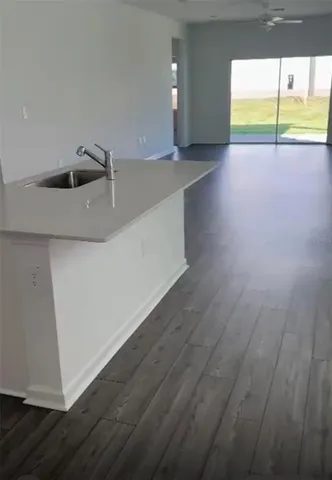 a view of an empty room and with kitchen