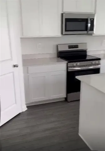 a kitchen with granite countertop a stove and a microwave