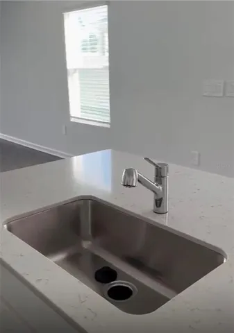 a close view of sink a faucet a toilet and a window