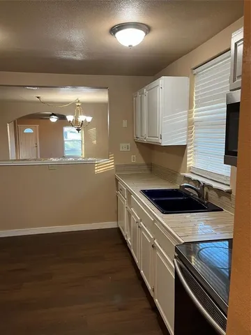 a kitchen with granite countertop a stove and a wooden floors