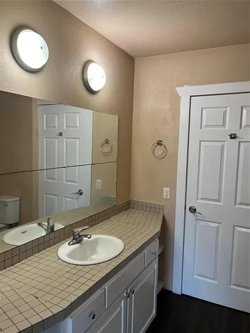 a bathroom with a granite countertop sink and a mirror