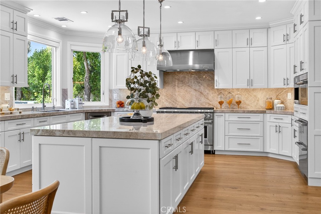 25714 Simpson Place Calabasas, CA 91302 - Photo 11 of 44 a kitchen with stainless steel appliances granite countertop a stove a sink and white cabinets with wooden floor