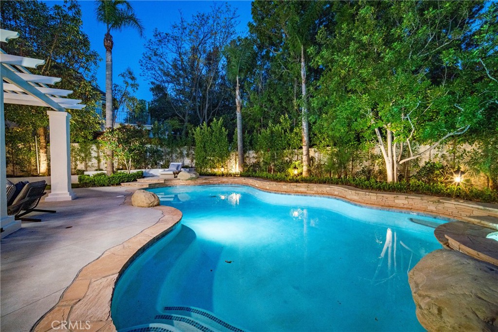 25714 Simpson Place Calabasas, CA 91302 - Photo 42 of 44 a view of a swimming pool with lawn chairs under an umbrella
