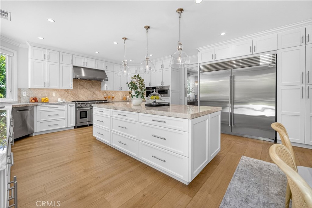 25714 Simpson Place Calabasas, CA 91302 - Photo 8 of 44 a kitchen with stainless steel appliances kitchen island granite countertop a stove a sink and a refrigerator