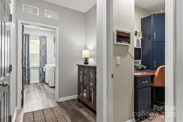 a view of a hallway with entryway and wooden floor