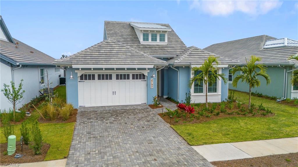 8795 Calypso Court Naples, FL 34113 - Photo 5 of 49 a front view of a house with garden