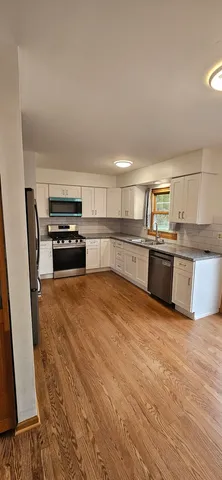 a large kitchen with stainless steel appliances granite countertop a stove and a refrigerator