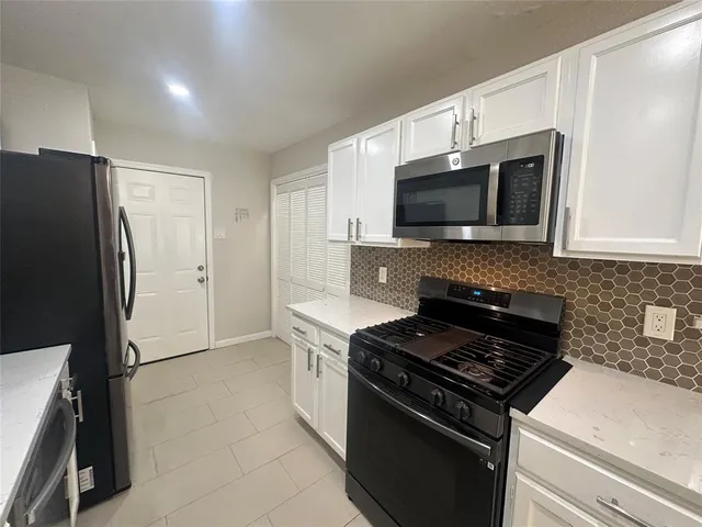 a kitchen with stainless steel appliances and cabinets