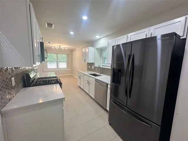a kitchen with stainless steel appliances a refrigerator sink and cabinets