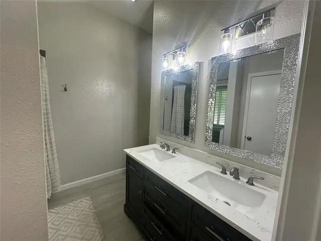 a bathroom with a double vanity sink and a mirror