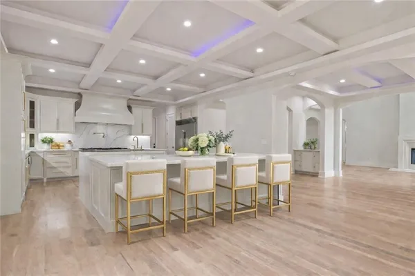 a kitchen with a dining table chairs and wooden floor
