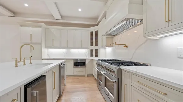 a kitchen with stainless steel appliances granite countertop a sink stove and cabinets