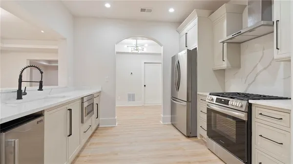 a kitchen with stainless steel appliances granite countertop a stove a sink and a refrigerator