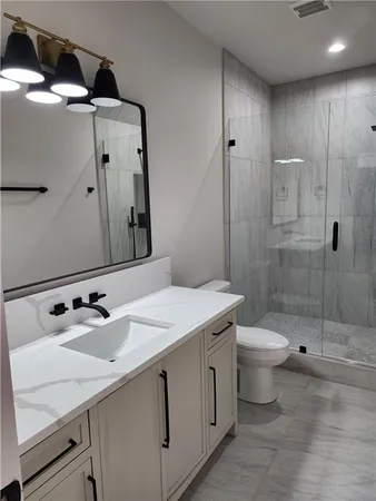 a bathroom with a sink a toilet and shower