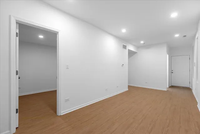 an empty room with wooden floor and closet area