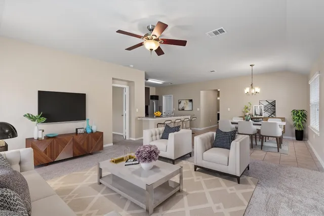 a living room with furniture kitchen view and a flat screen tv
