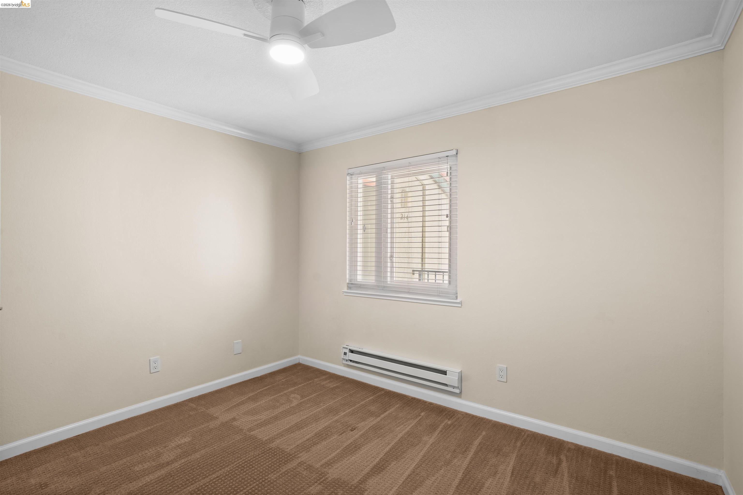 1505 Kirker Pass Road, Unit 214 Concord, CA 94521 - Photo 41 of 55 Neutral-toned room featuring a white ceiling fan with integrated lighting, a single window with blinds, baseboard heating, and light brown patterned carpeting