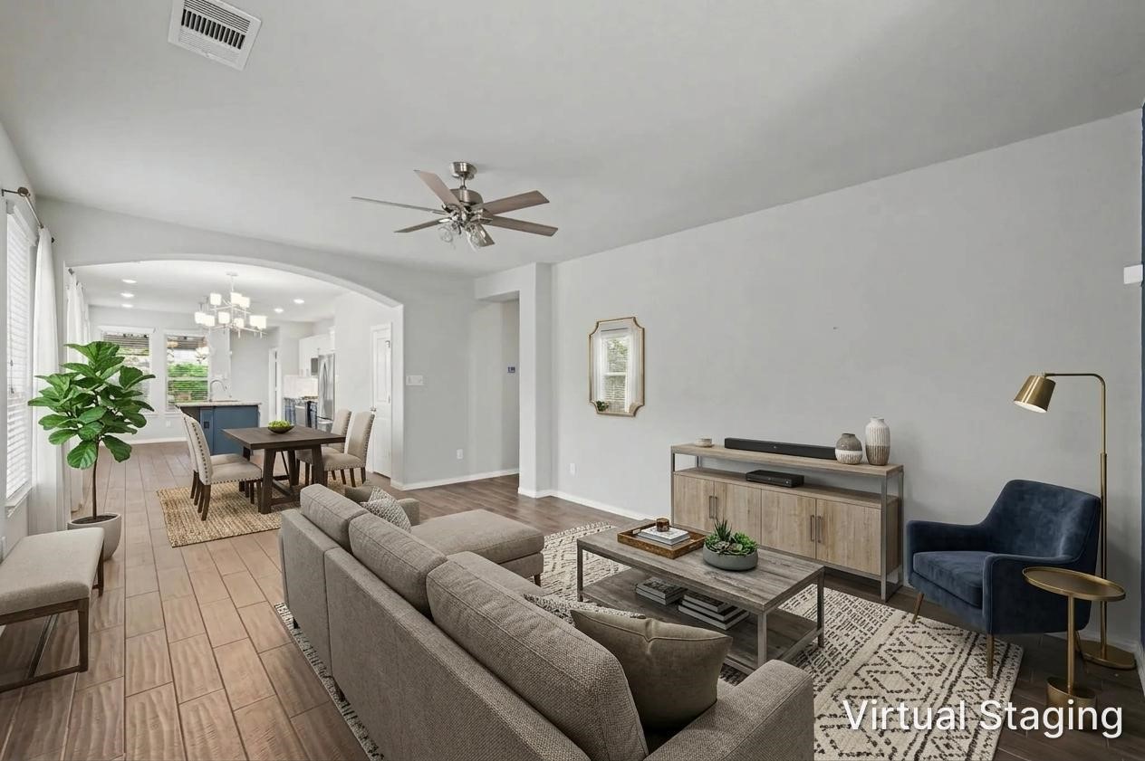 Virtually staged photo showing the open-concept living, dining, and kitchen areas.