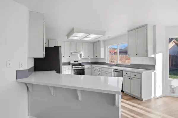 a kitchen with stainless steel appliances a refrigerator sink and microwave