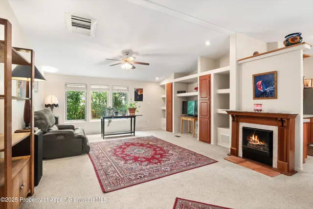 a living room with furniture large window and a fireplace