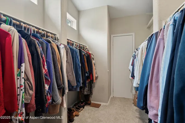 a view of walk in closet with clothes