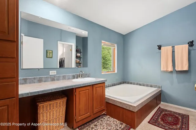 a bathroom with a sink a mirror and a window