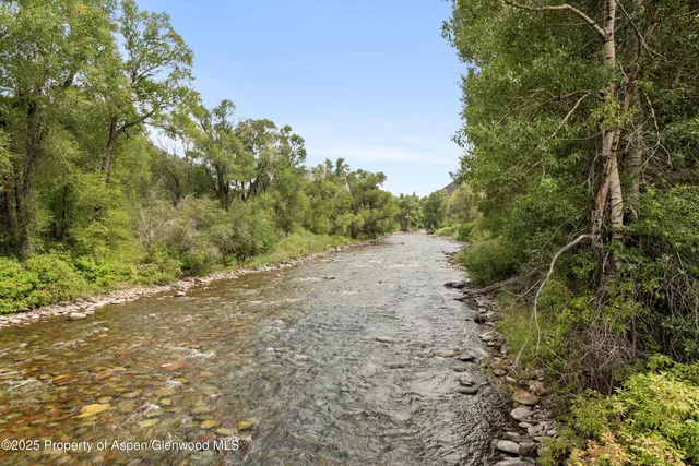 a view of a dirt road with trees in the background