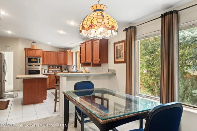 a dining room with furniture and a large window