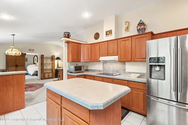 a kitchen with stainless steel appliances granite countertop a refrigerator a sink dishwasher a stove and white cabinets with wooden floor