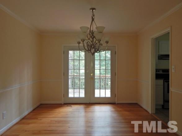 5013 Will-O-Dean Road Raleigh, NC 27616 - Photo 6 of 15 an empty room with wooden floor chandelier and windows