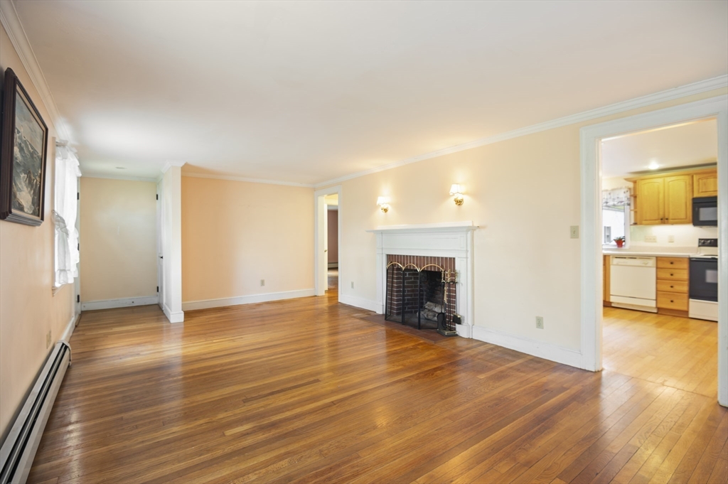 110 Linden Street Hamilton, MA 01982 - Photo 9 of 25 a view of a livingroom with wooden floor and a fireplace