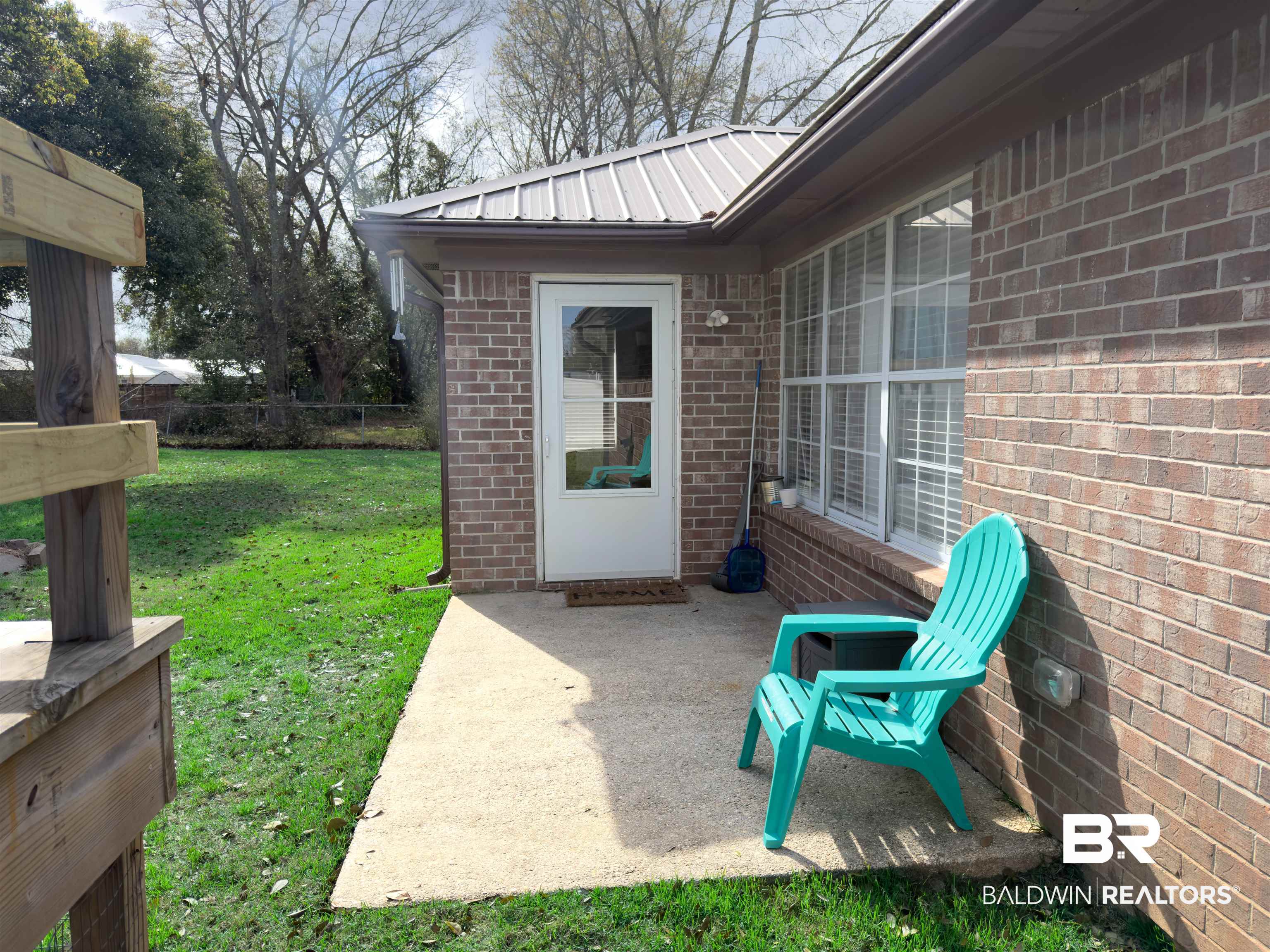 129 Pennbrooke Loop Foley, AL 36535 - Photo 43 of 44 Property entrance featuring a metal roof, brick siding, and a patio