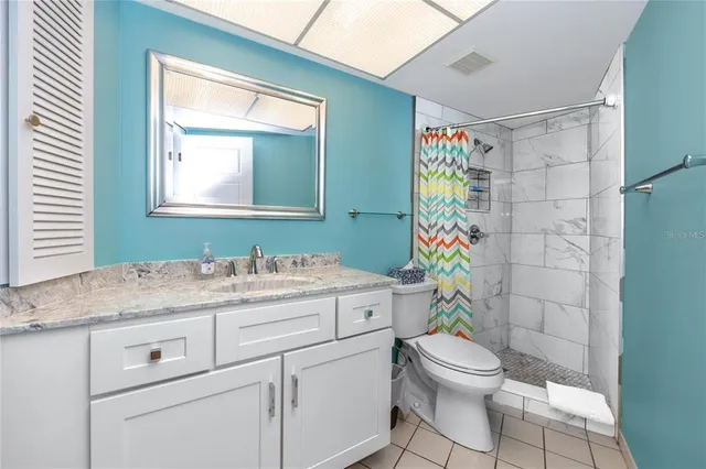 a bedroom with a bed and lamp on dresser