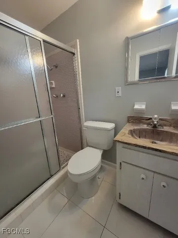 a bathroom with a granite countertop toilet sink and shower