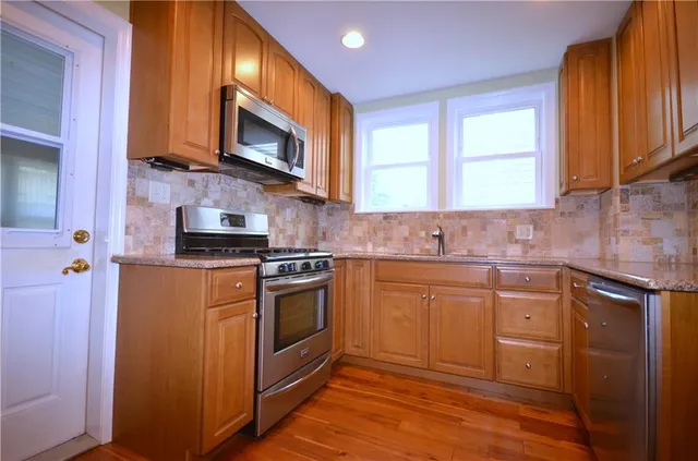 a kitchen with stainless steel appliances granite countertop a sink stove and microwave