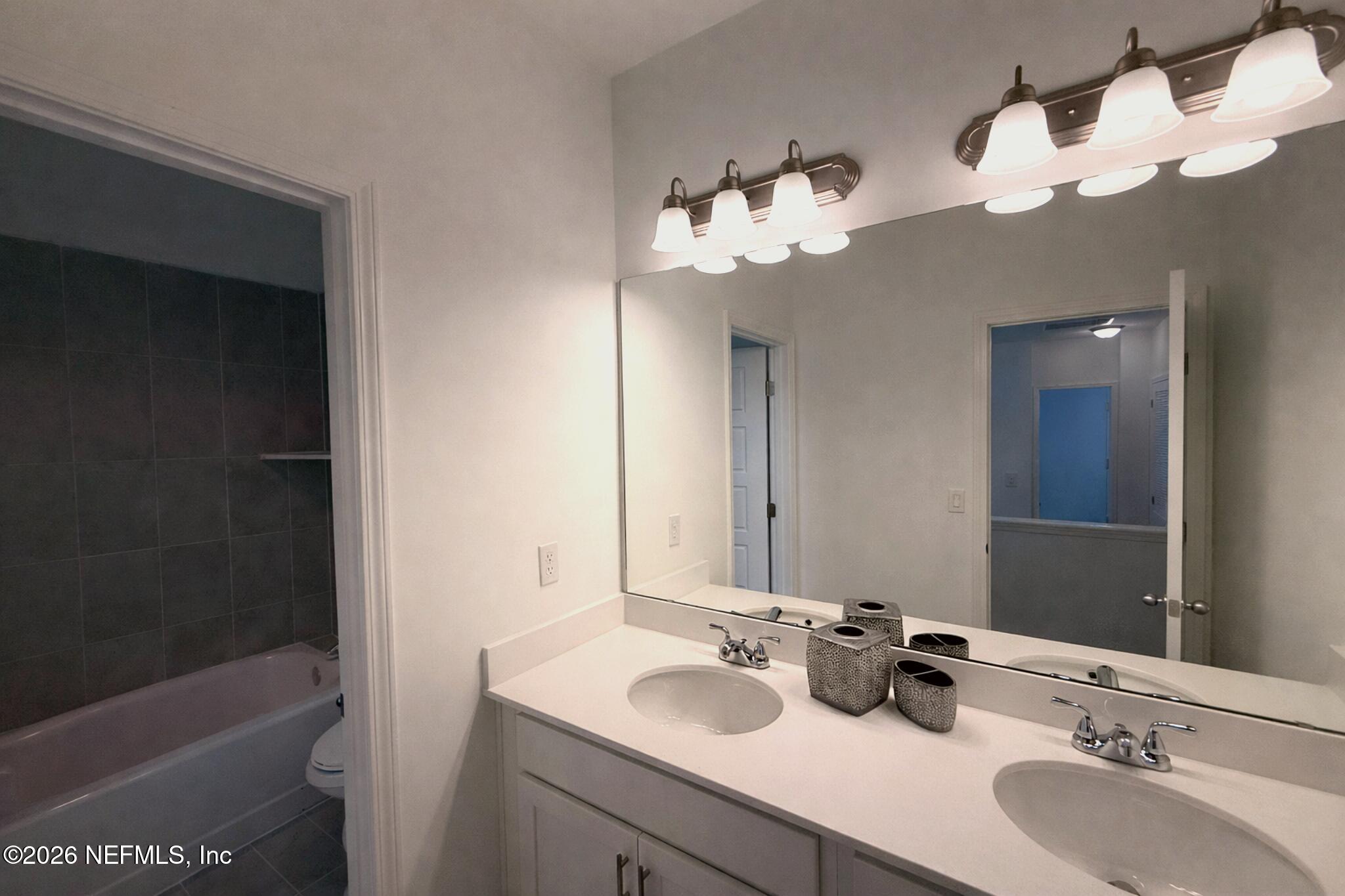 2913 Fleur Lane Jacksonville, FL 32205 - Photo 17 of 22 a bathroom with a sink a tub and a mirror