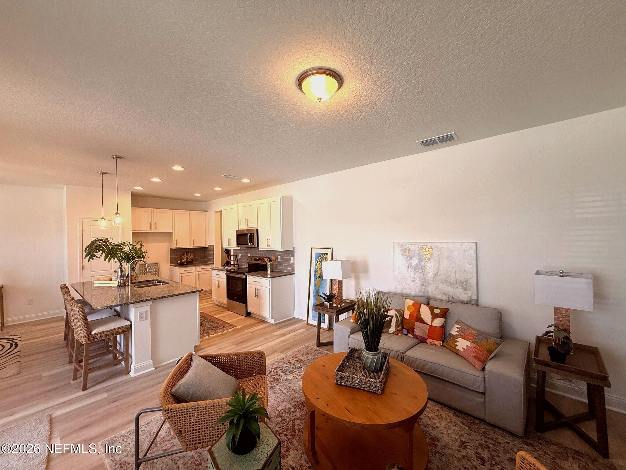 2913 Fleur Lane Jacksonville, FL 32205 - Photo 4 of 22 a living room with furniture kitchen view and a wooden floor