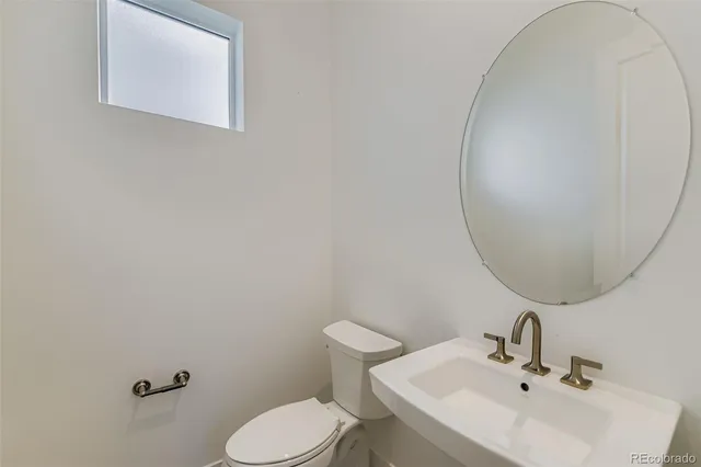 a bathroom with a sink mirror and toilet