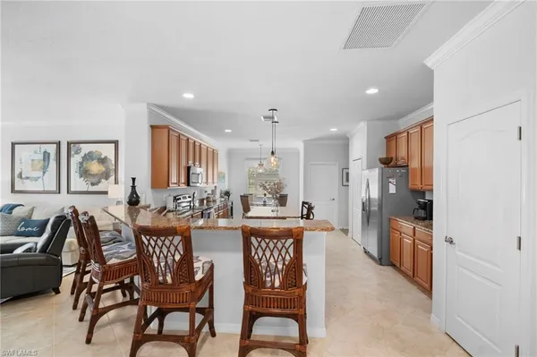 a kitchen with stainless steel appliances granite countertop a stove top oven a sink refrigerator and cabinets