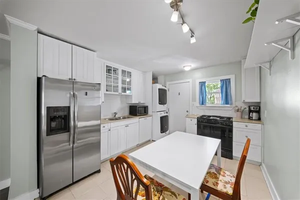 a kitchen with white cabinets and stainless steel appliances