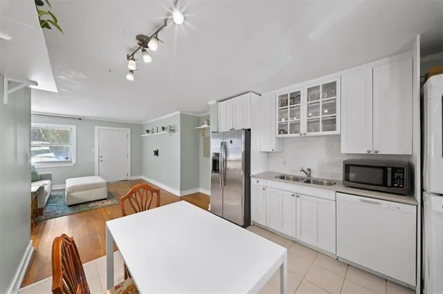 a kitchen that has a lot of cabinets a sink a stove and wooden floor
