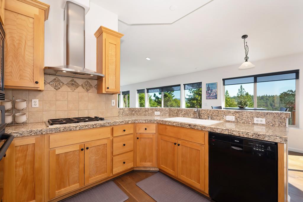 19676 Eagle Ridge Road Foresthill, CA 95631 - Photo 26 of 68 a kitchen with stainless steel appliances granite countertop white cabinets and a window