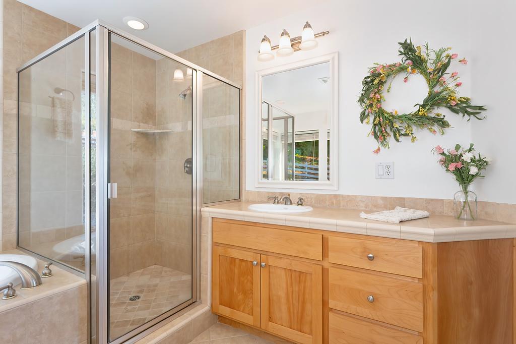 19676 Eagle Ridge Road Foresthill, CA 95631 - Photo 36 of 68 a bathroom with a granite countertop sink a mirror and a shower