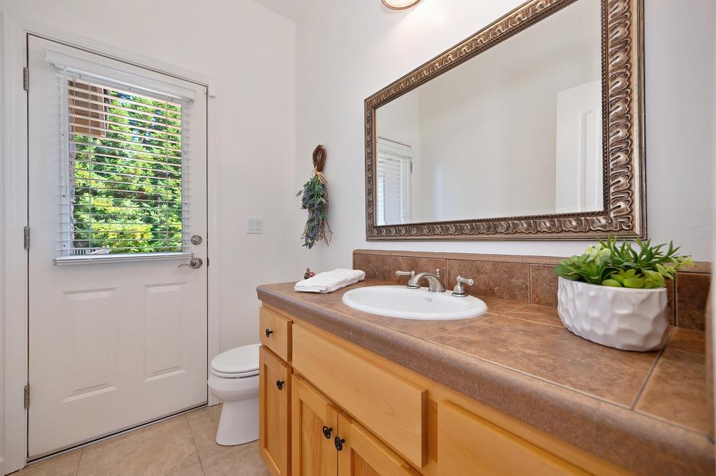 19676 Eagle Ridge Road Foresthill, CA 95631 - Photo 40 of 68 a bathroom with a granite countertop sink and a mirror